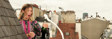 Woman wearing Boden blouse popping champagne