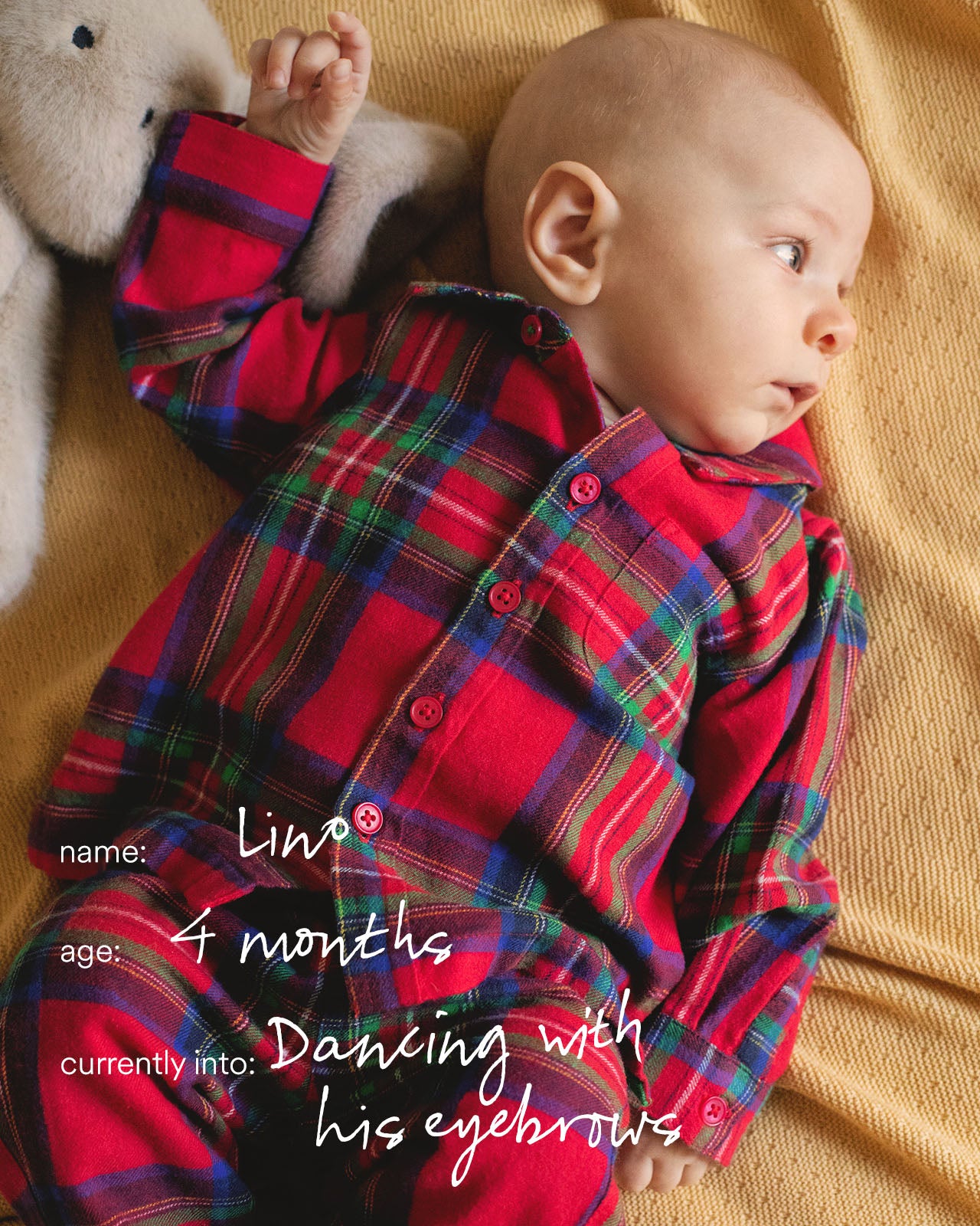 Baby in a red plaid shirt lying on a yellow blanket with text about the baby's name, age, and activities.
