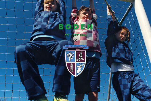 Three children playing behind a soccer net with 'Boden' branding.