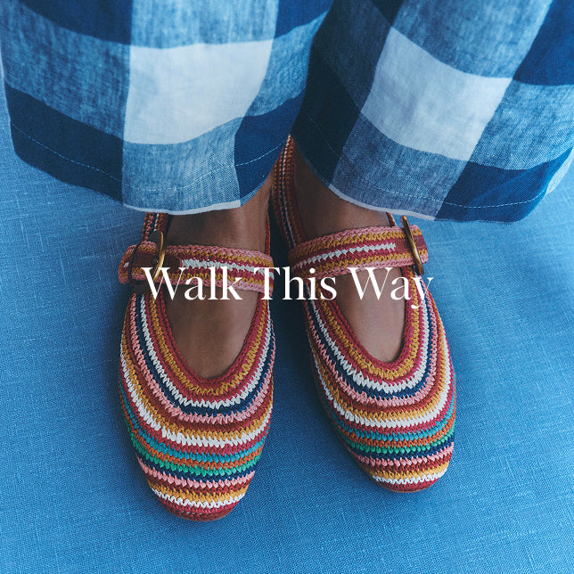 Colorful striped shoes worn with blue checkered pants on a blue background, with 'Walk This Way' text overlay.