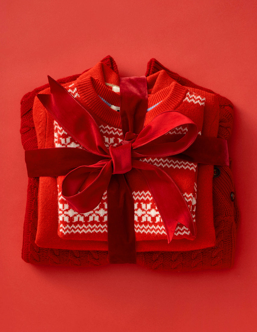 Red sweater with a decorative bow on a red background