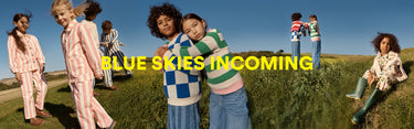 Children in colourful outfits standing on grass with 'Blue Skies Incoming' text overlay.
