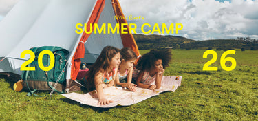 Three children lying on a blanket in front of a tent with 'Summer Camp 2026' text.
