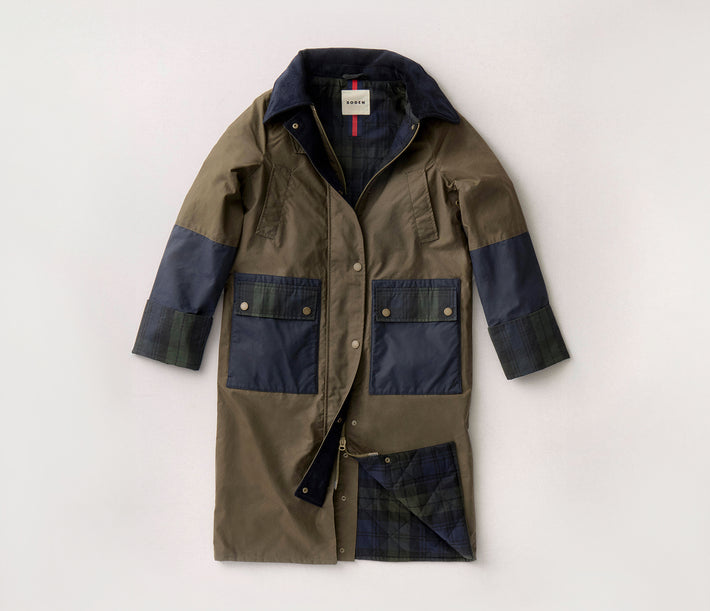 Green and navy coat with a visible brand label on a light grey background