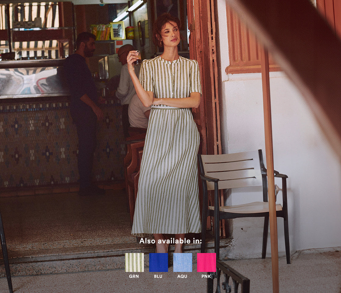 Woman in a striped dress standing in a room with vintage decor.