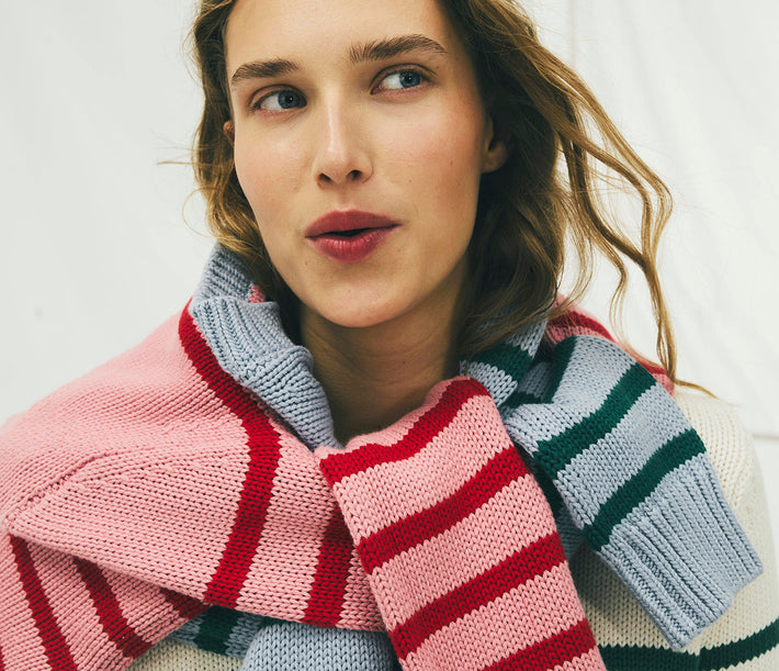 Woman wearing a colorful striped scarf against a white background
