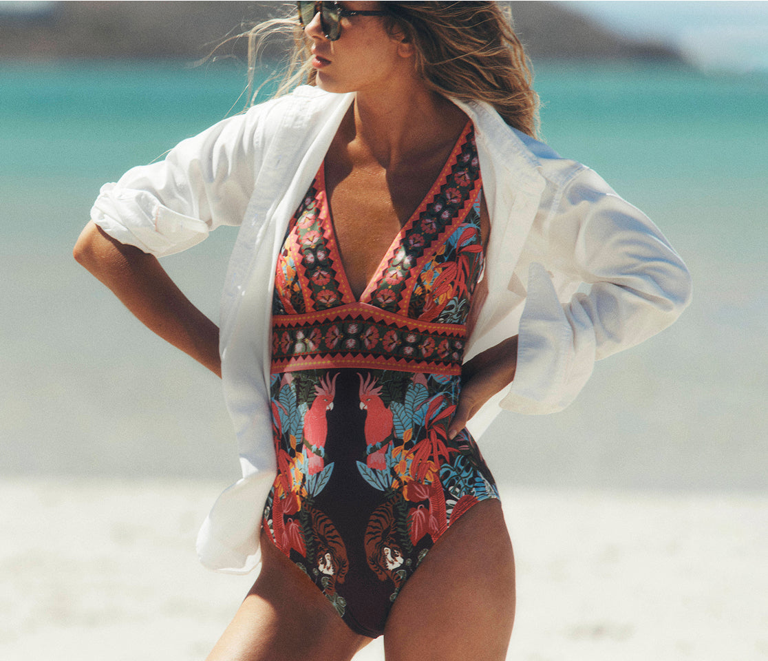 Woman in a colorful swimsuit with a white cover-up on a beach