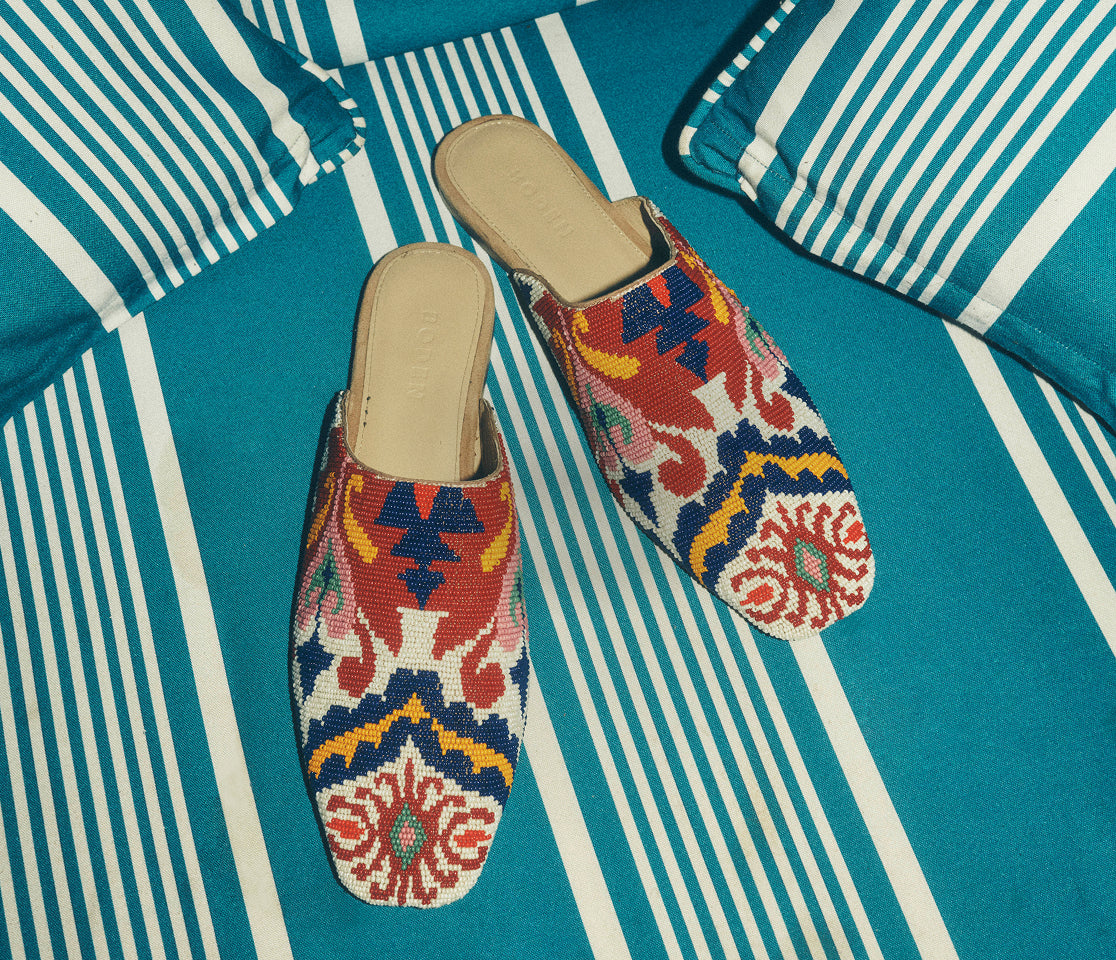 Colorful embroidered slippers on a blue and white striped fabric background