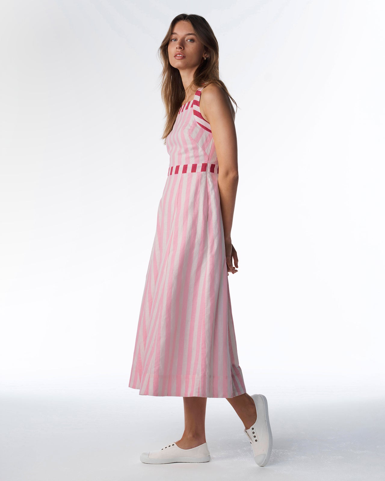 Woman wearing a pink and white striped dress on a white background