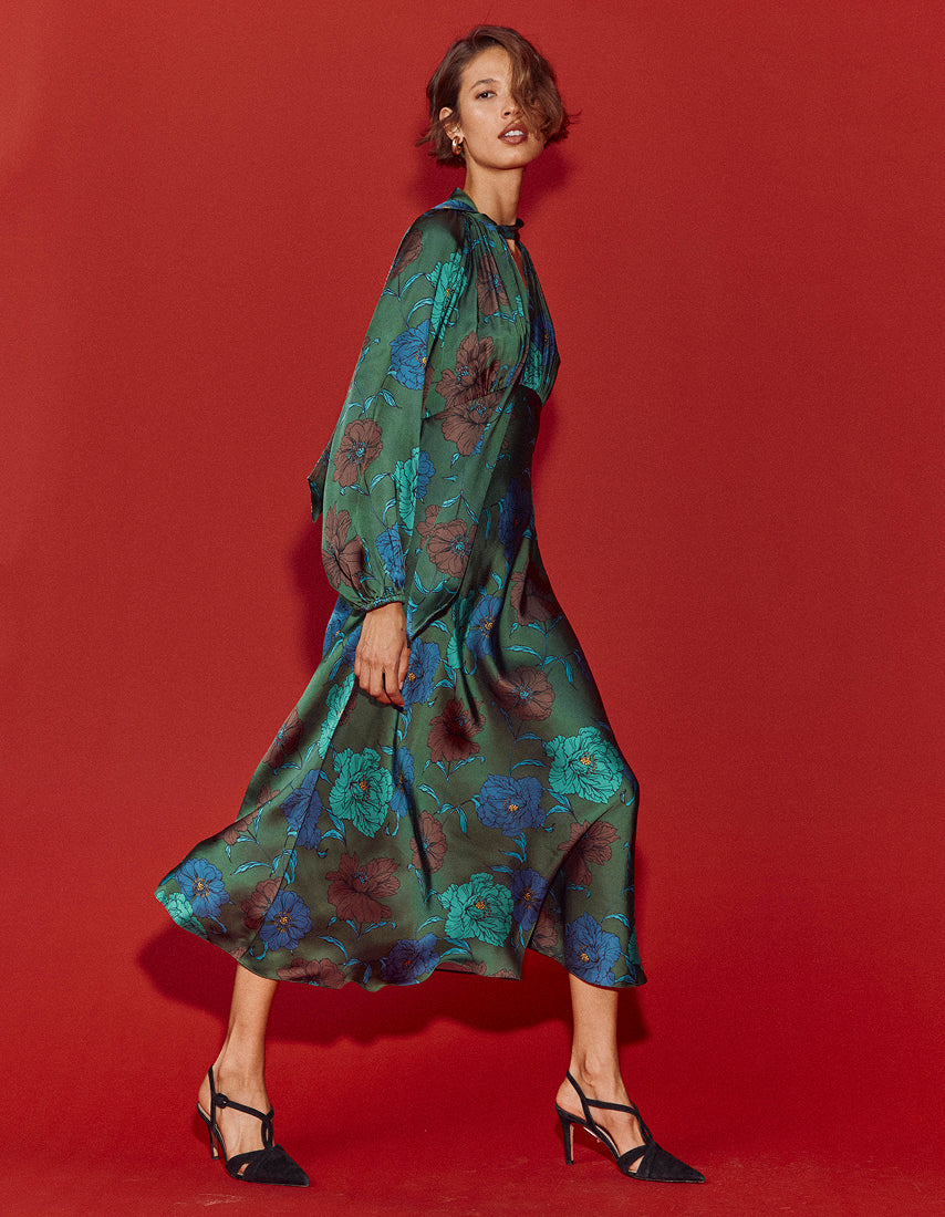 Woman wearing a green floral dress against a red background