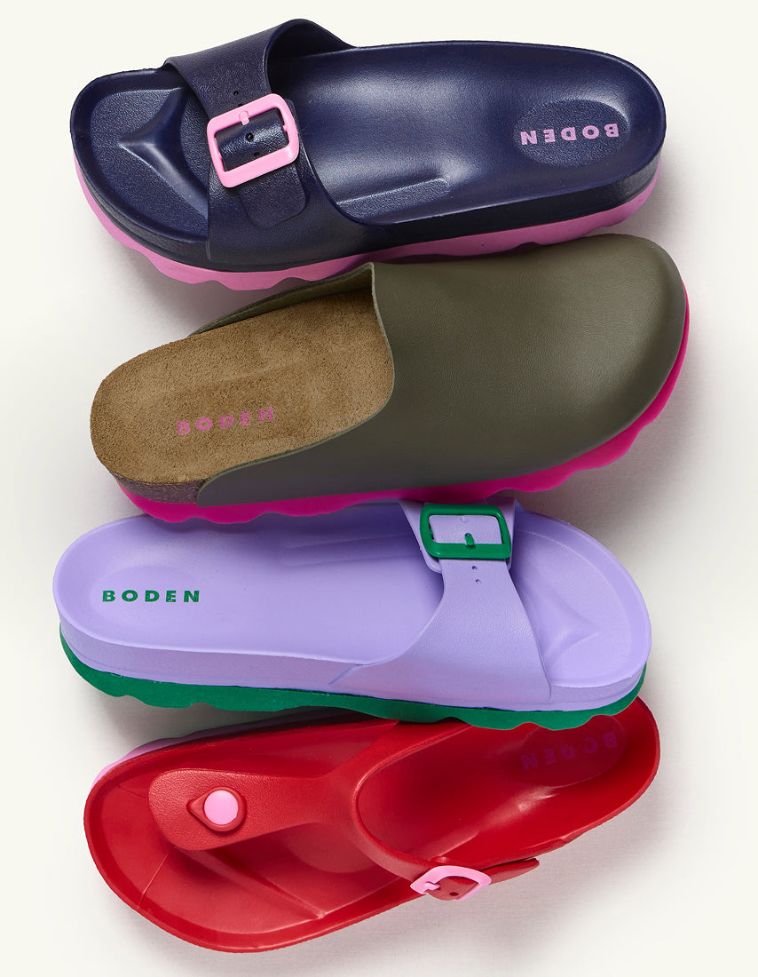 Four colorful sandals stacked on a white background with 'Boden' branding.