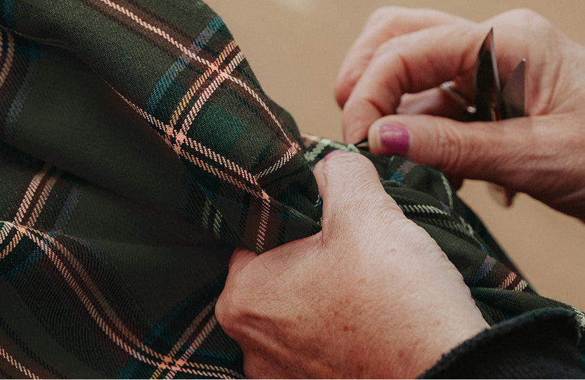 Woman sewing tartan fabric