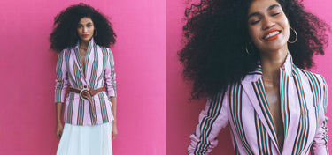 Woman in a striped blazer against a pink background