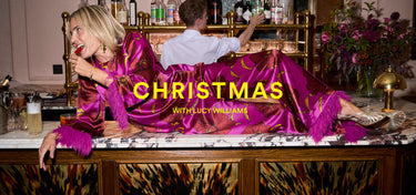 Women in a festive attire sitting at a bar with 'Christmas with Lucy Williams' text overlay.
