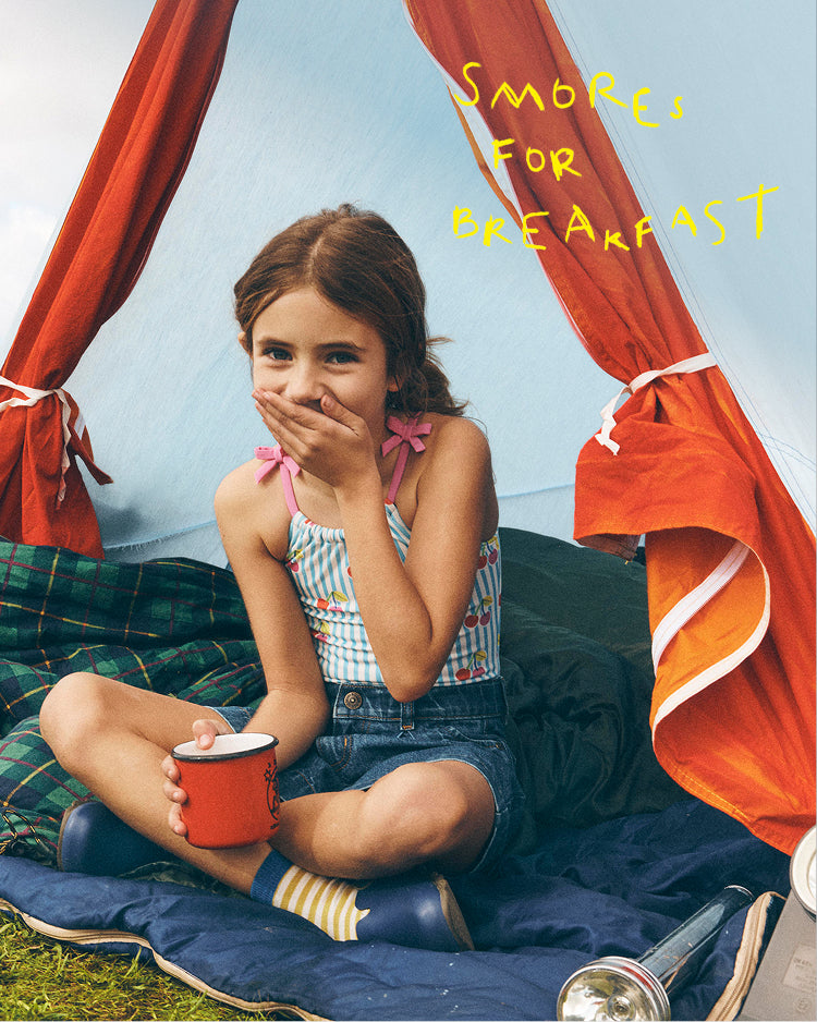 Young girl sitting inside a tent with 'Smore for Breakfast' text above her.