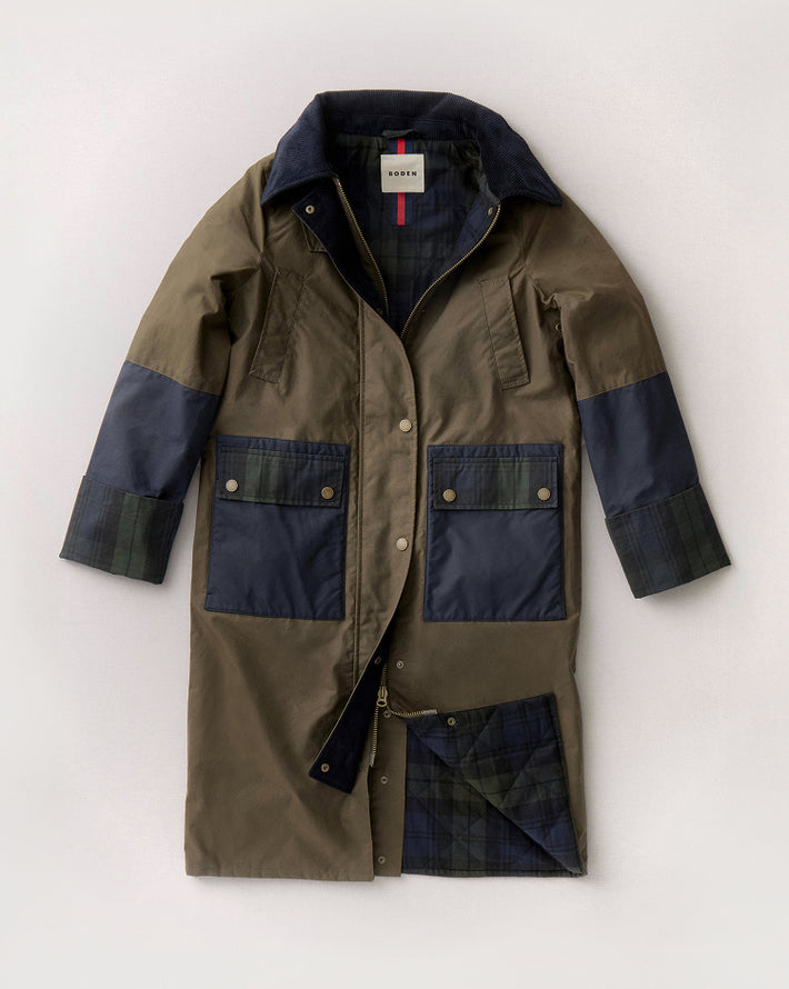 Green and navy coat with a visible brand label on a light grey background