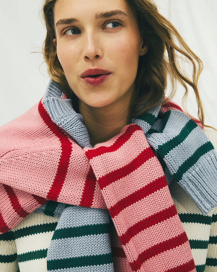 Woman wearing a colorful striped scarf against a light background