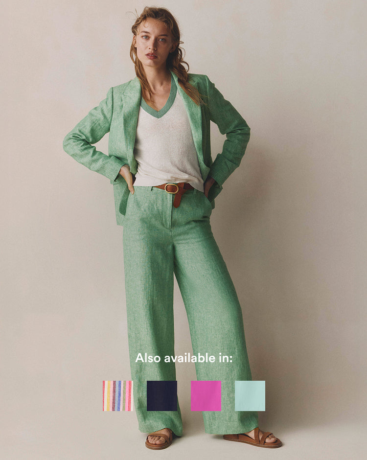 Woman wearing a green suit with a plain background