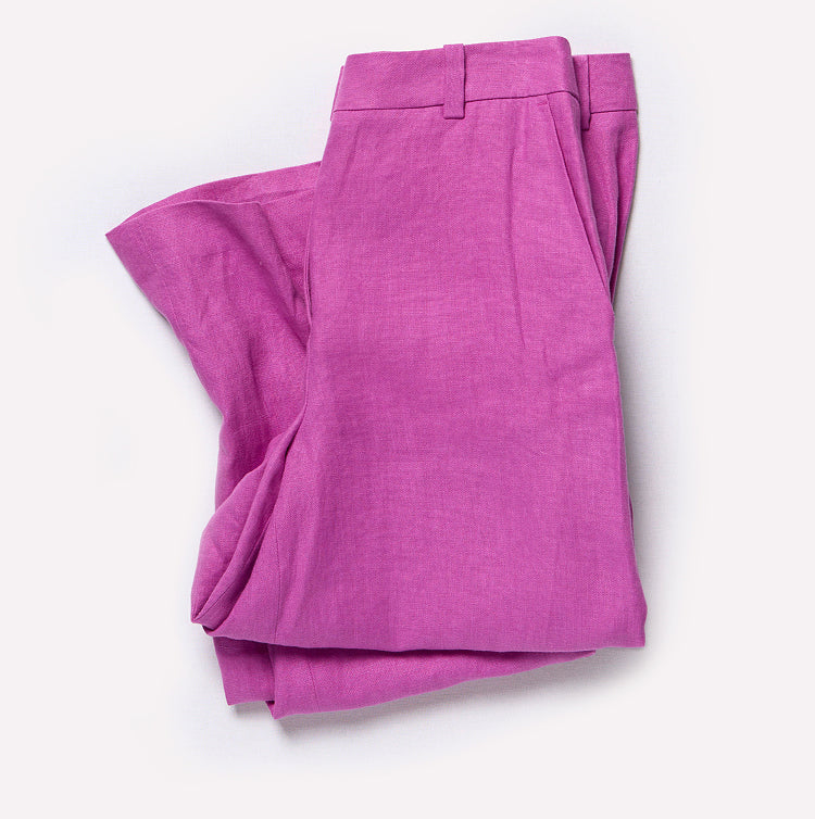 Folded pink pants on a white background