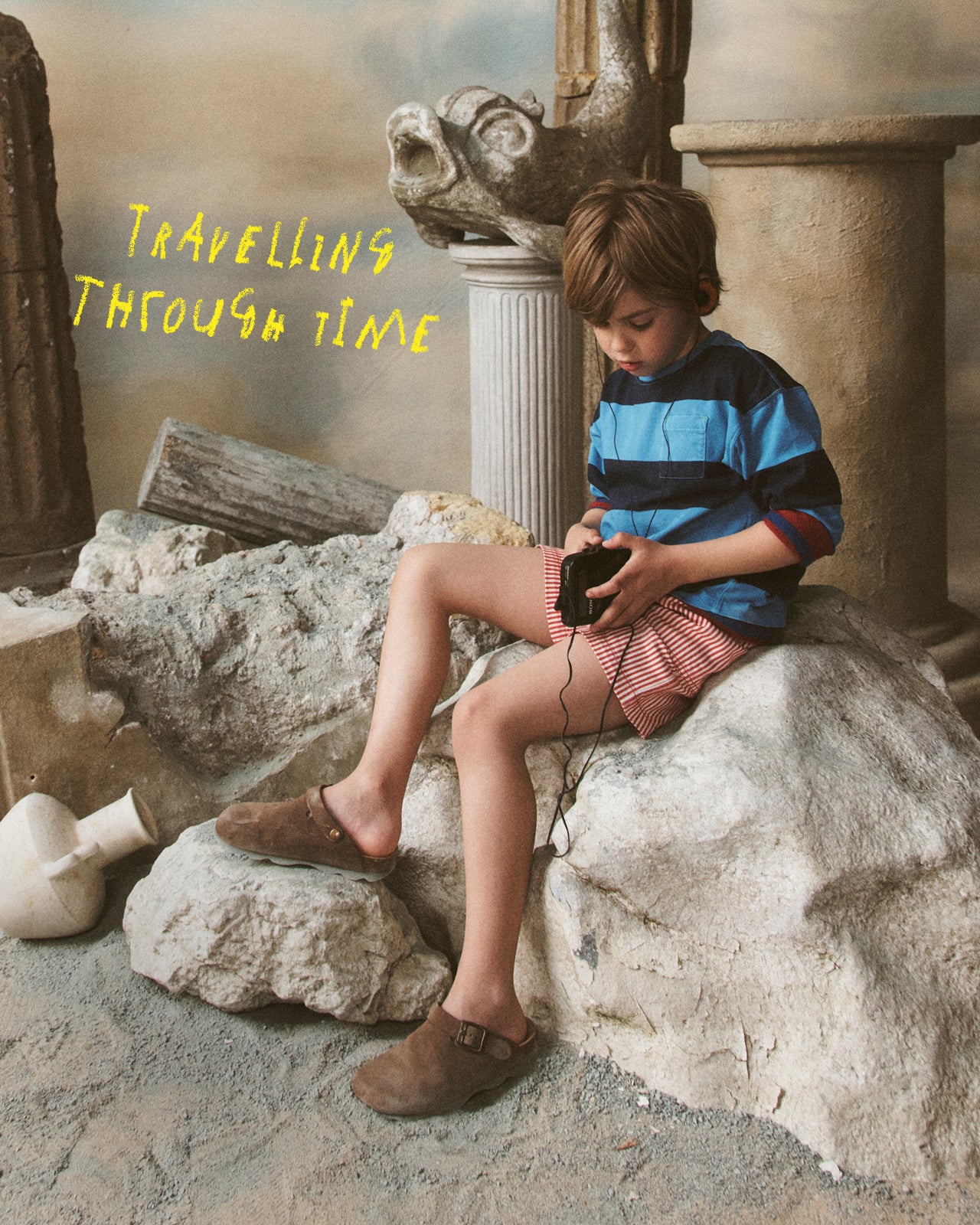 Child sitting on stone ruins using a smartphone with text 'Travelling Through Time'.