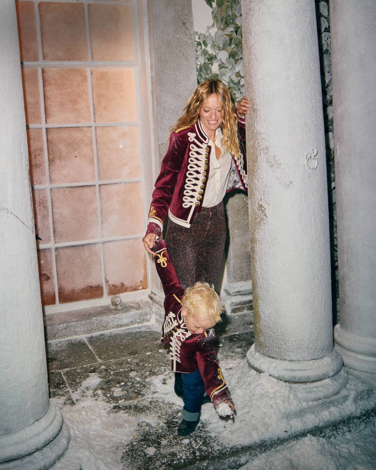 Woman standing outside with a little boy wearing matching jackets with embroidery detail. 